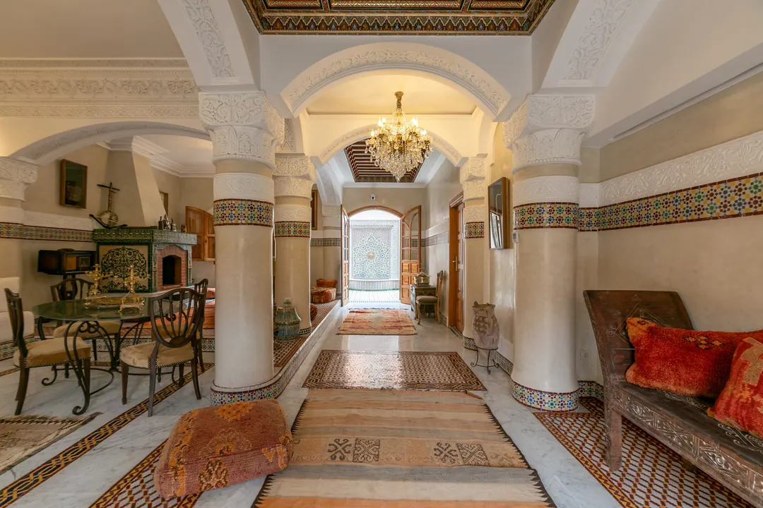 Arched gallery with a long Berber runner leading through the riad