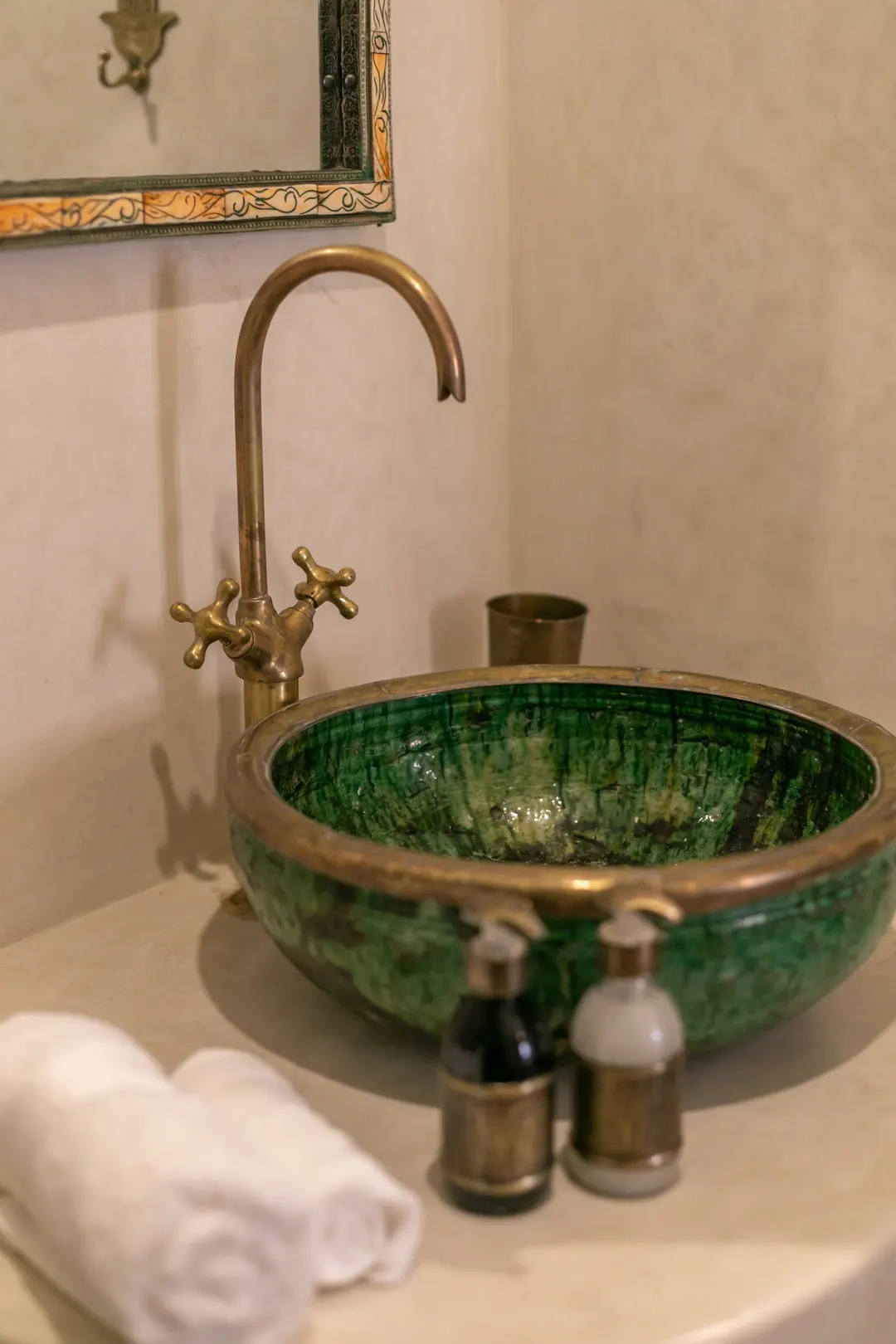 Emerald room bathroom with a hand-glazed green basin and brass fittings
