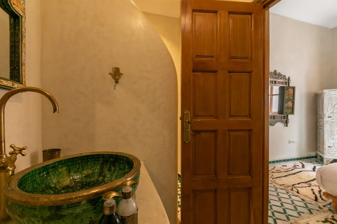 Emerald room bathroom with a hand-glazed green basin and brass fittings