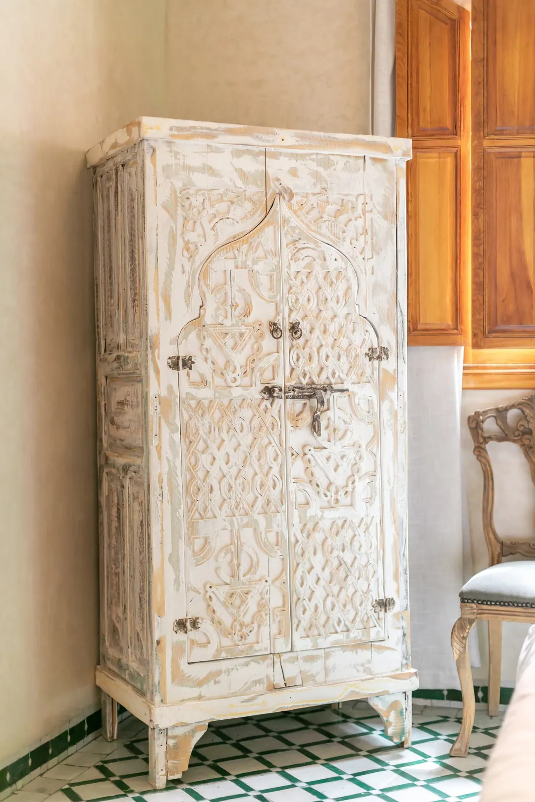 Emerald room: carved headboard on an emerald tadelakt wall, green lantern and zellige floor