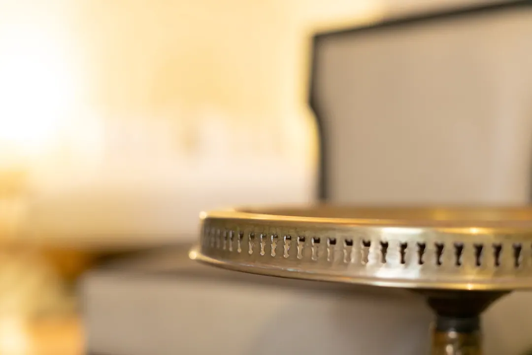 Ivory room: carved plaster headboard, bedside lamps and a black-and-white zellige floor