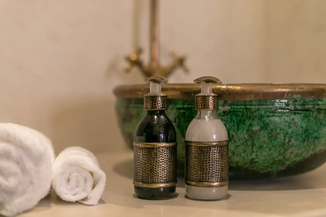 Emerald room bathroom with a hand-glazed green basin and brass fittings