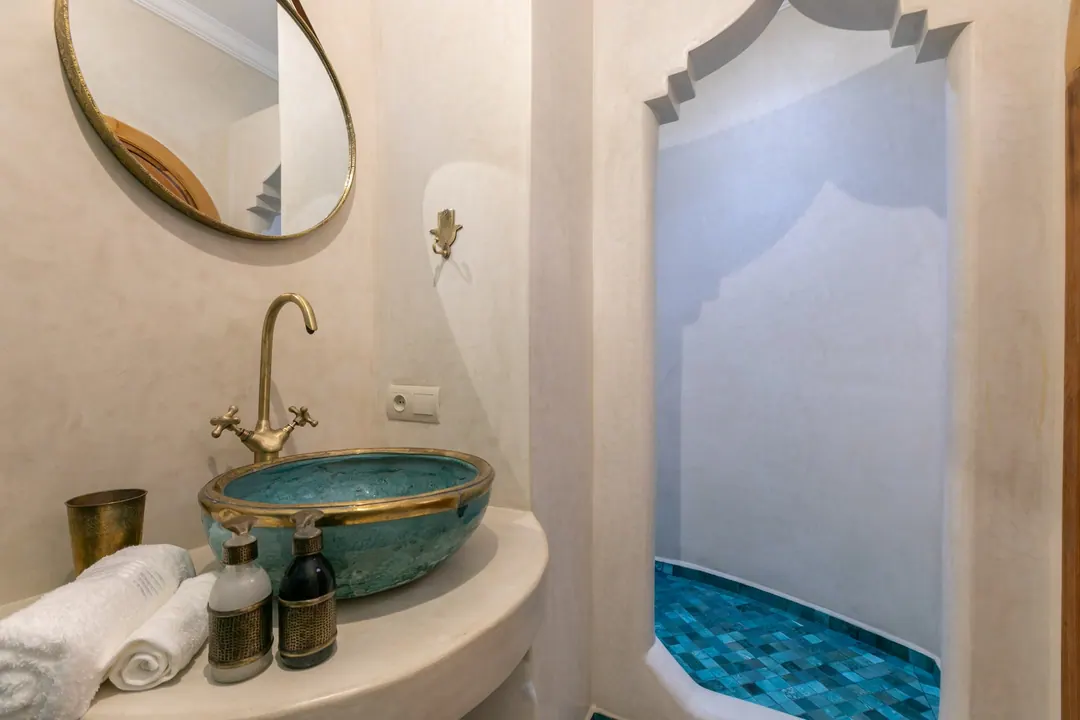 Turquoise room bathroom with a copper basin and blue mosaic shower