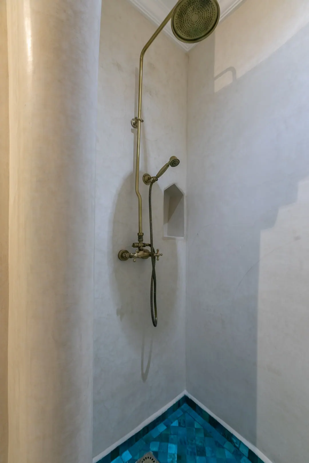 Turquoise room bathroom with a copper basin and blue mosaic shower