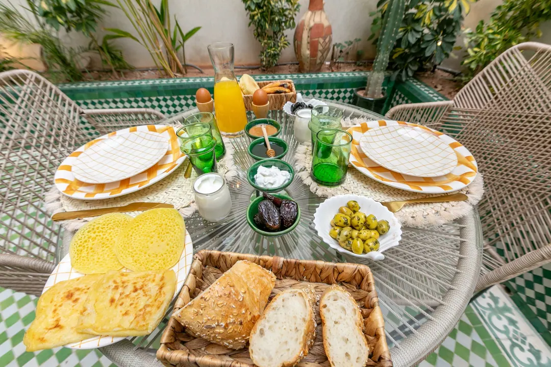 Moroccan breakfast with msemmen, baghrir, eggs, olives, honey and fresh orange juice