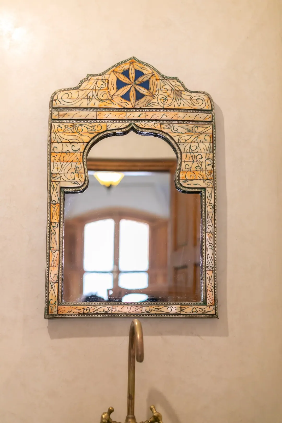 Emerald room: carved headboard on an emerald tadelakt wall, green lantern and zellige floor
