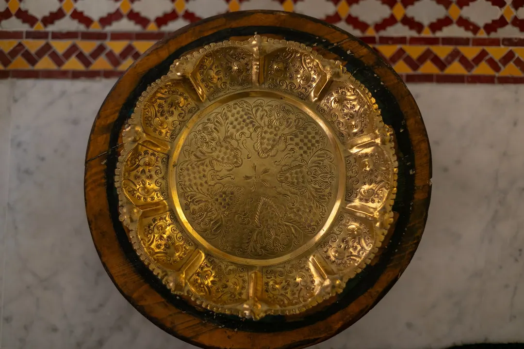 Engraved brass tray on a marble floor