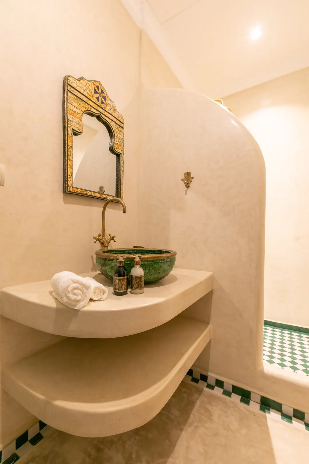 Emerald room bathroom with a hand-glazed green basin and brass fittings