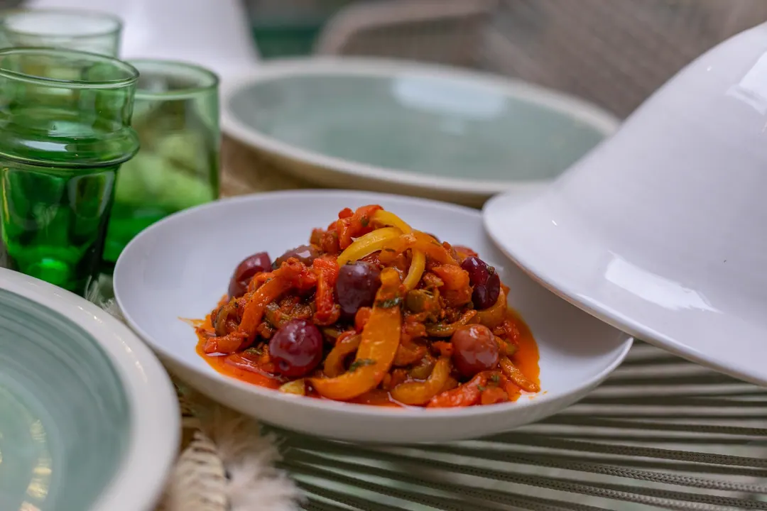 Lunch of seasonal tagines served under white ceramic lids on the patio