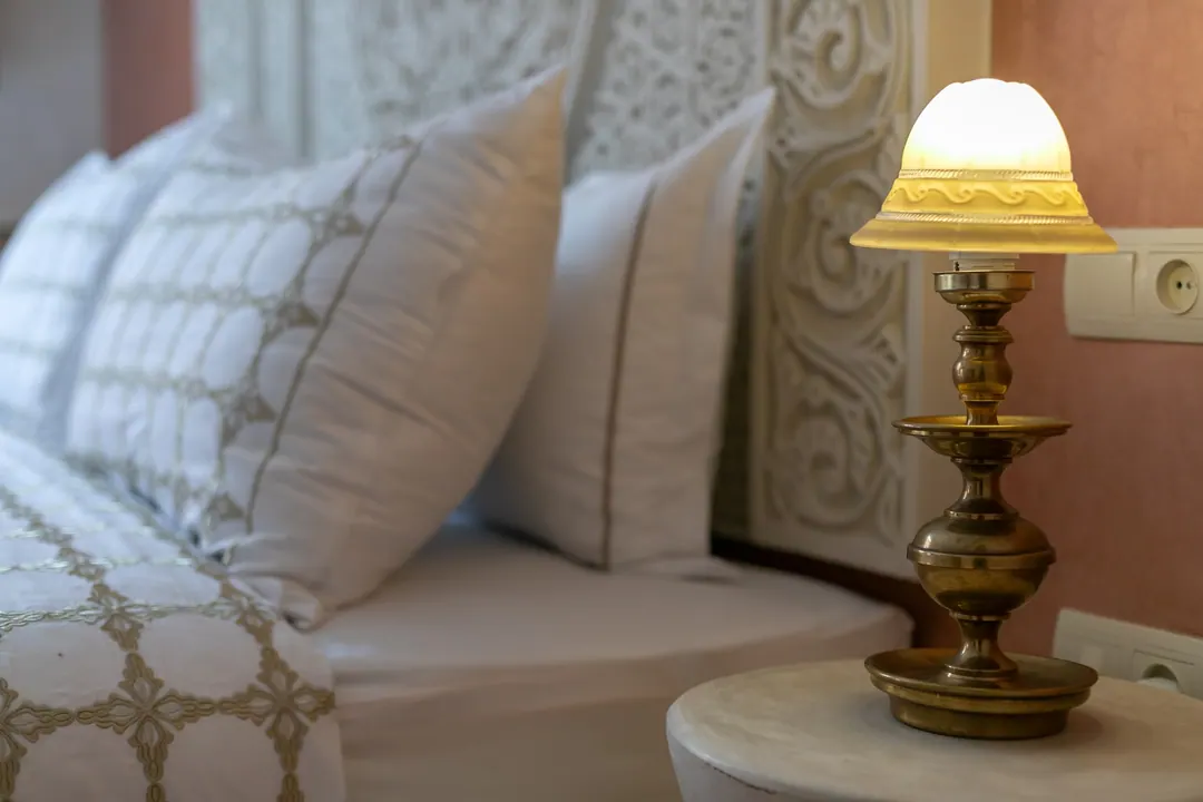 Embroidered linen pillows against a carved headboard