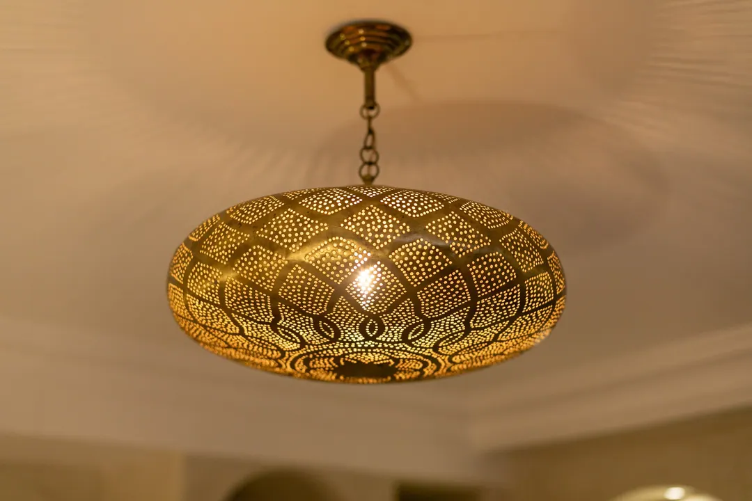 Hand-pierced brass lantern casting patterned light