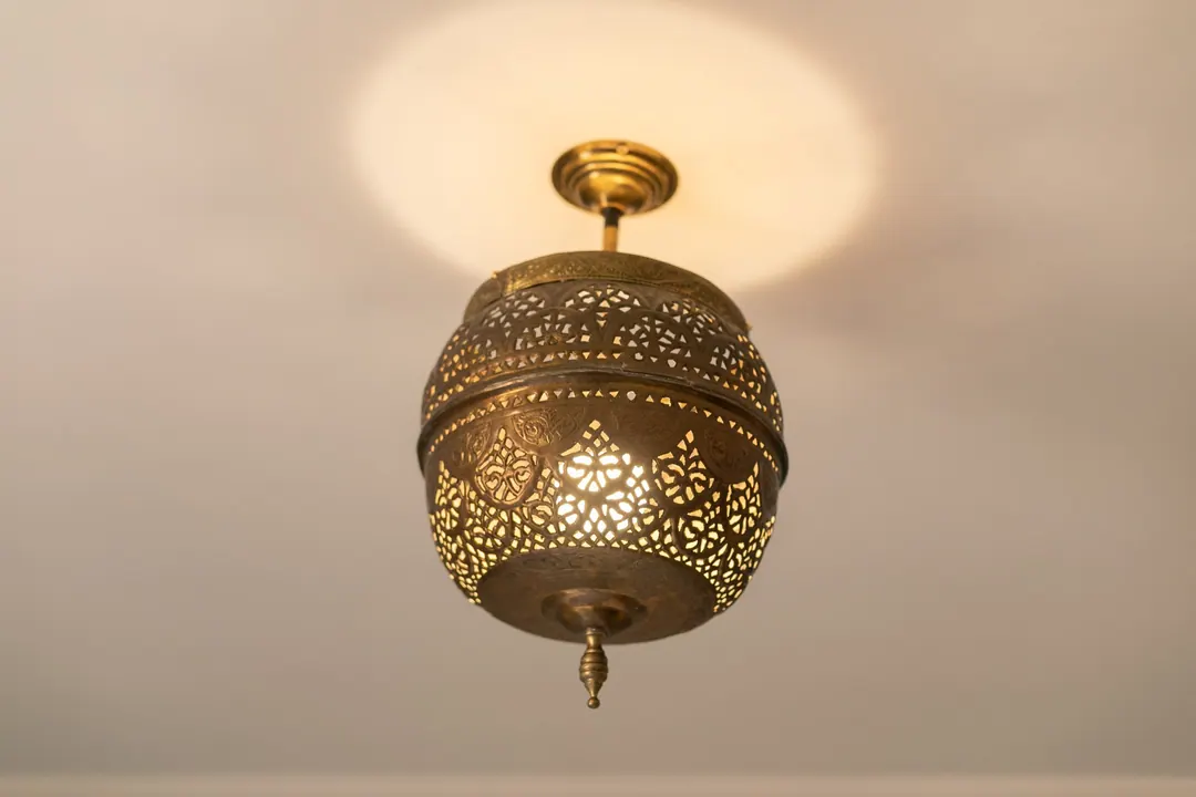 Hand-pierced brass lantern casting patterned light