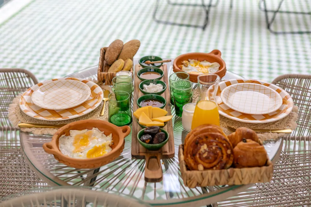 Moroccan breakfast with msemmen, baghrir, eggs, olives, honey and fresh orange juice