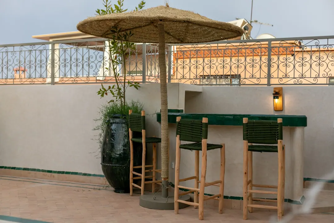 Rooftop bar with green zellige counter and woven stools