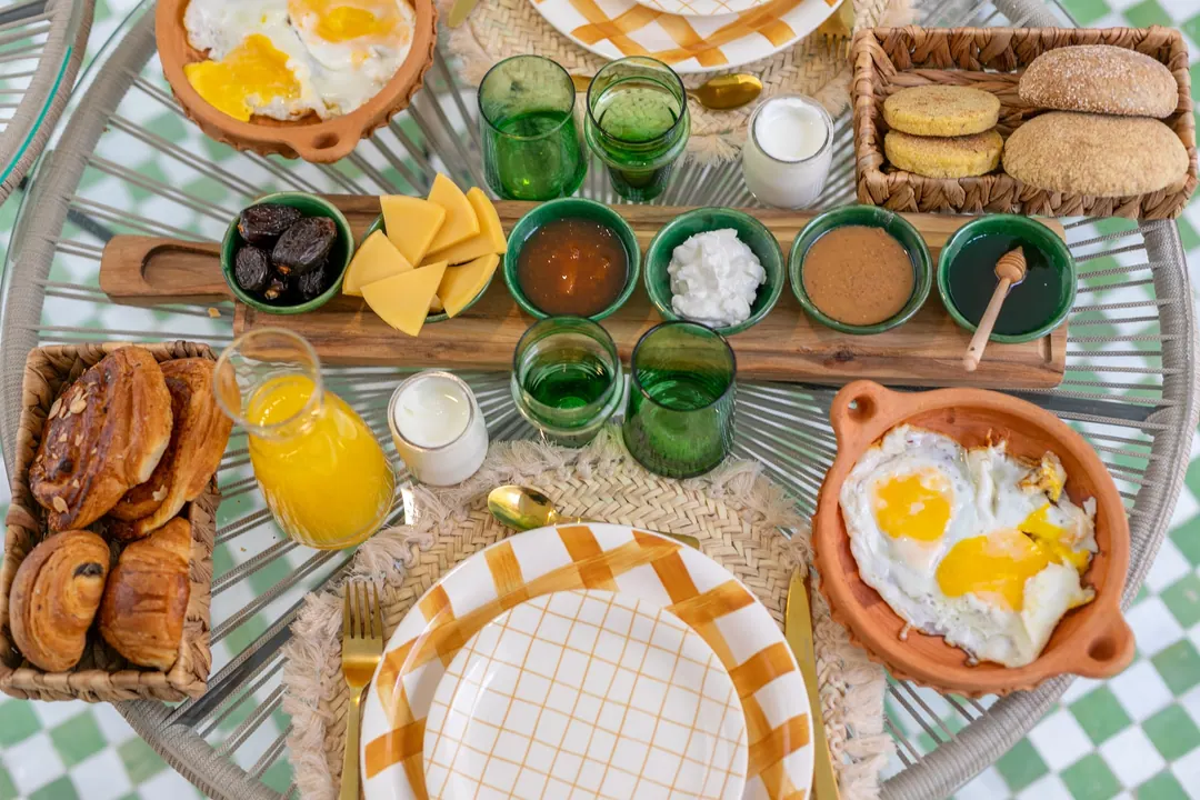 Moroccan breakfast with msemmen, baghrir, eggs, olives, honey and fresh orange juice