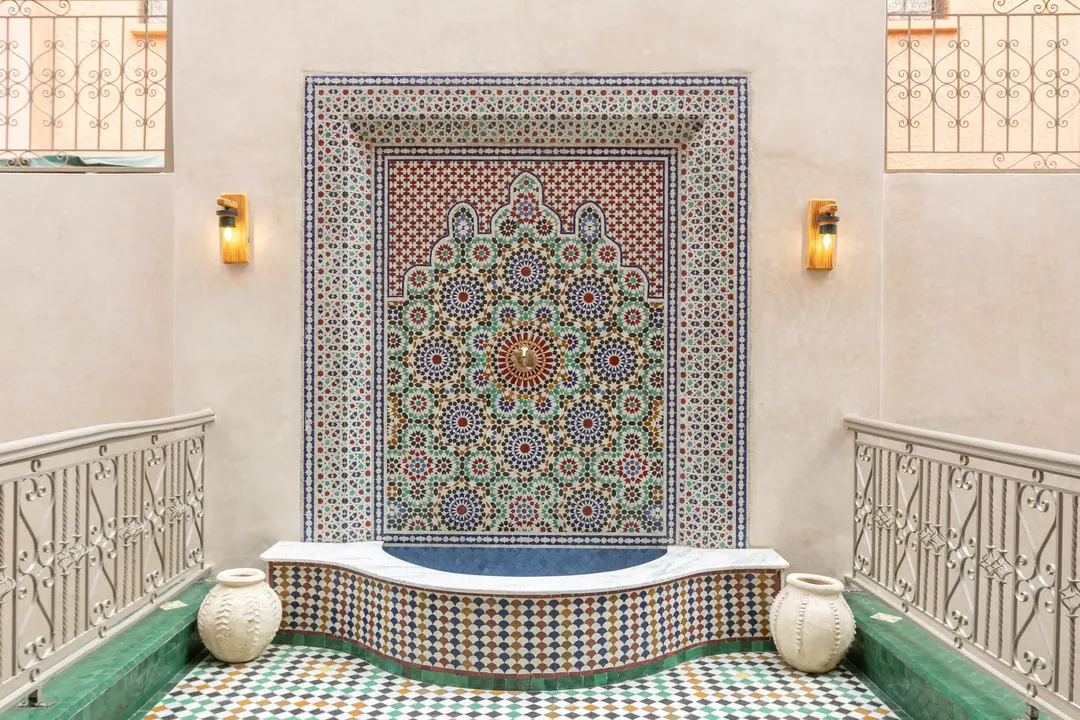 Zellige wall fountain with a carved surround in the inner courtyard