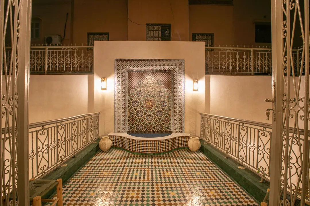Zellige wall fountain with a carved surround in the inner courtyard