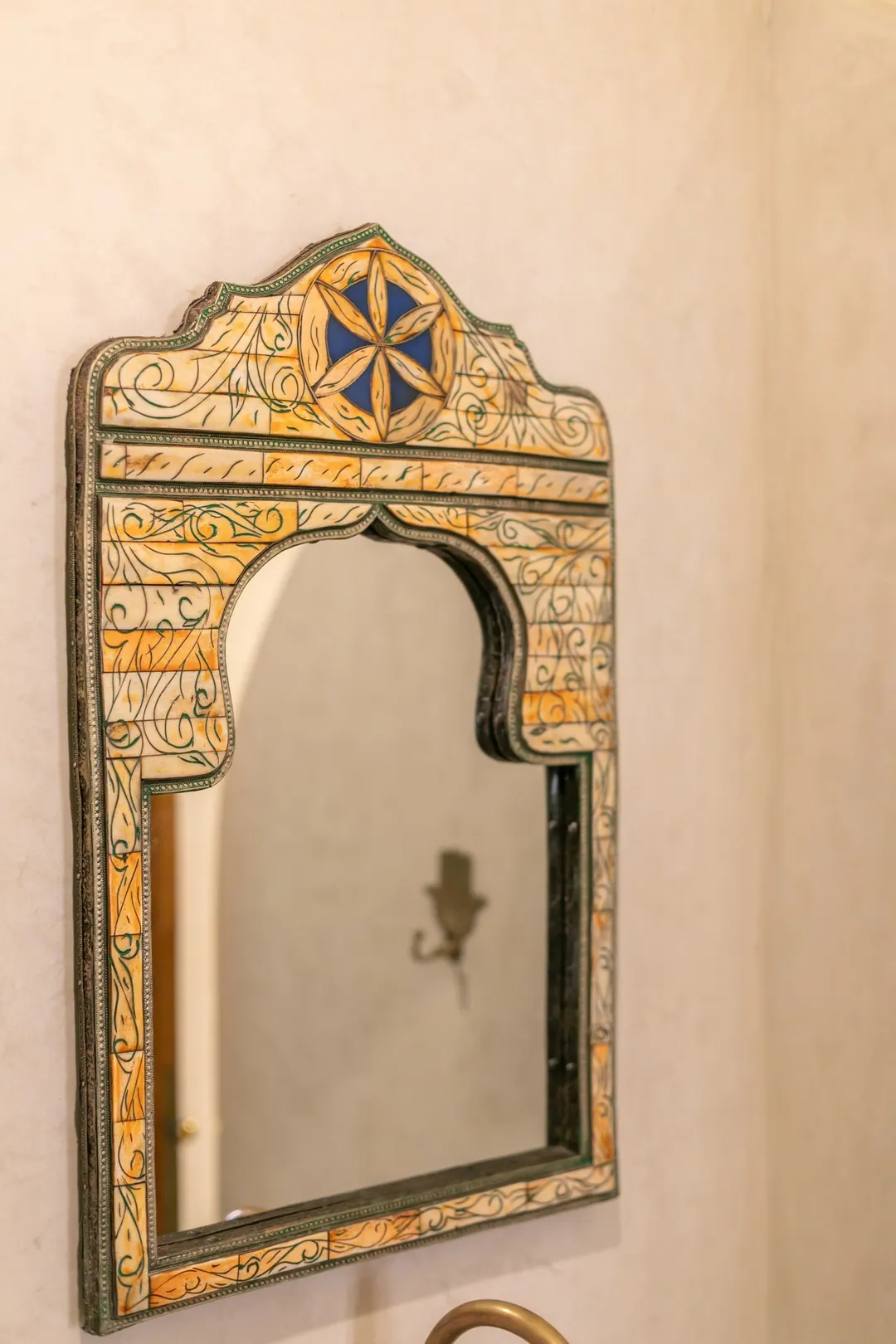 Emerald room: carved headboard on an emerald tadelakt wall, green lantern and zellige floor